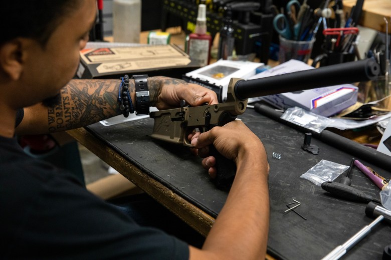 Gunsmith Jonathan Brooks works on assembling a rifle at Rifle Supply in Huntington Beach on Sept. 21, 2023. Photo by Alisha Jucevic for CalMatters