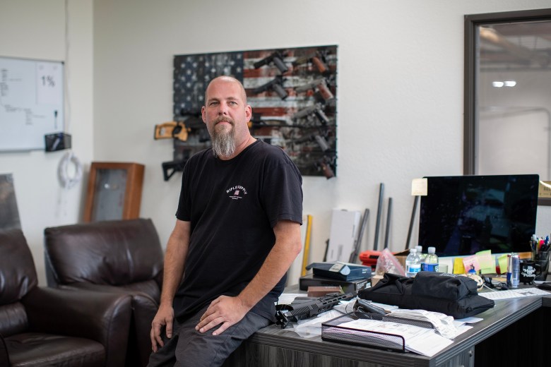 Owner John Koukios in his office at Rifle Supply in Huntington Beach on Sept. 21, 2023. Koukios said he grew up in Huntington Beach and although it may be cost efficient for the business to set up shop in a different state, this is his home. He said he doesn’t see himself moving but would consider opening a secondary store in another state. Photo by Alisha Jucevic for CalMatters