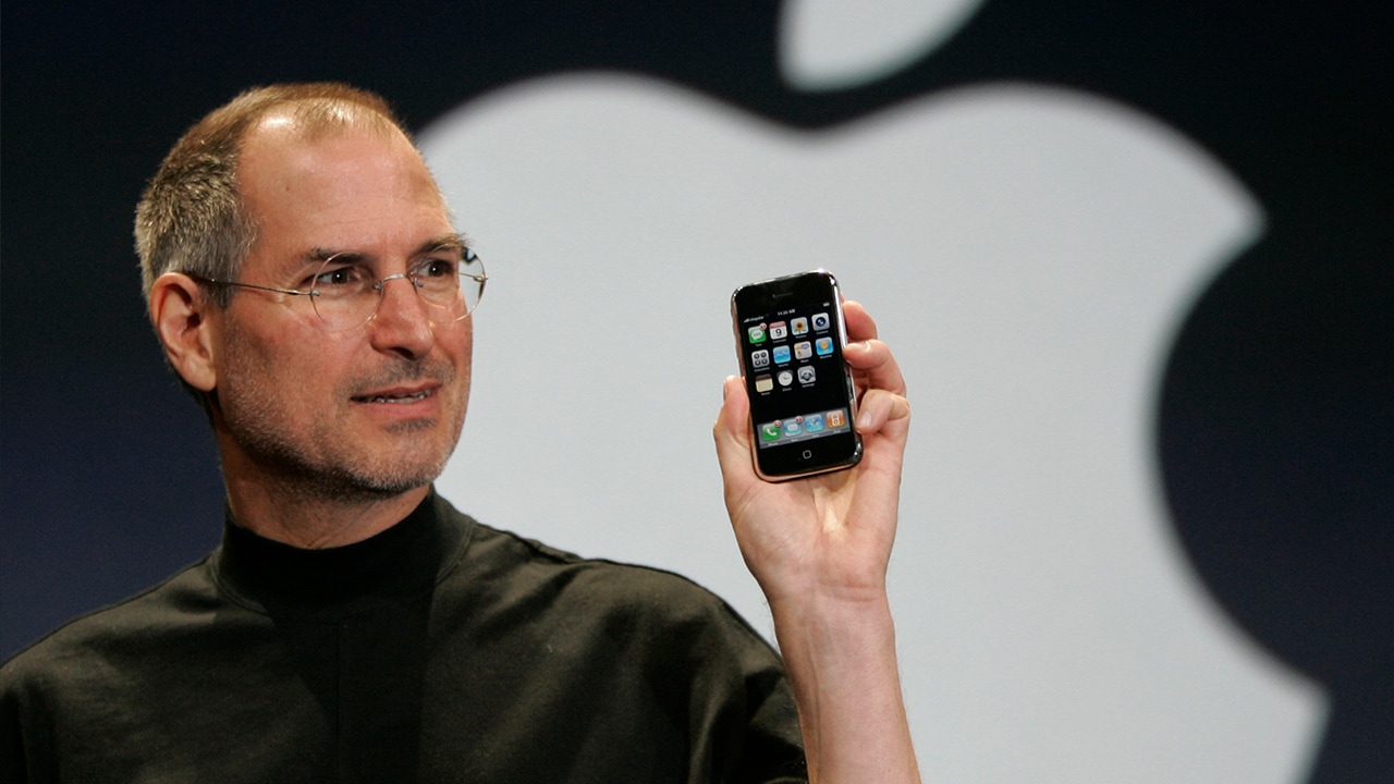 Photo of Steve Jobs holding up iPhone