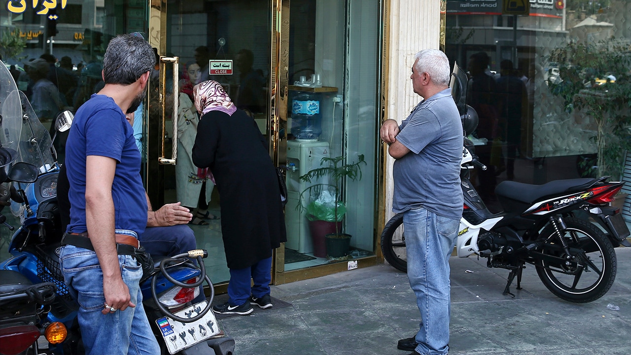 People waiting outside of a money exchange shop in Iran