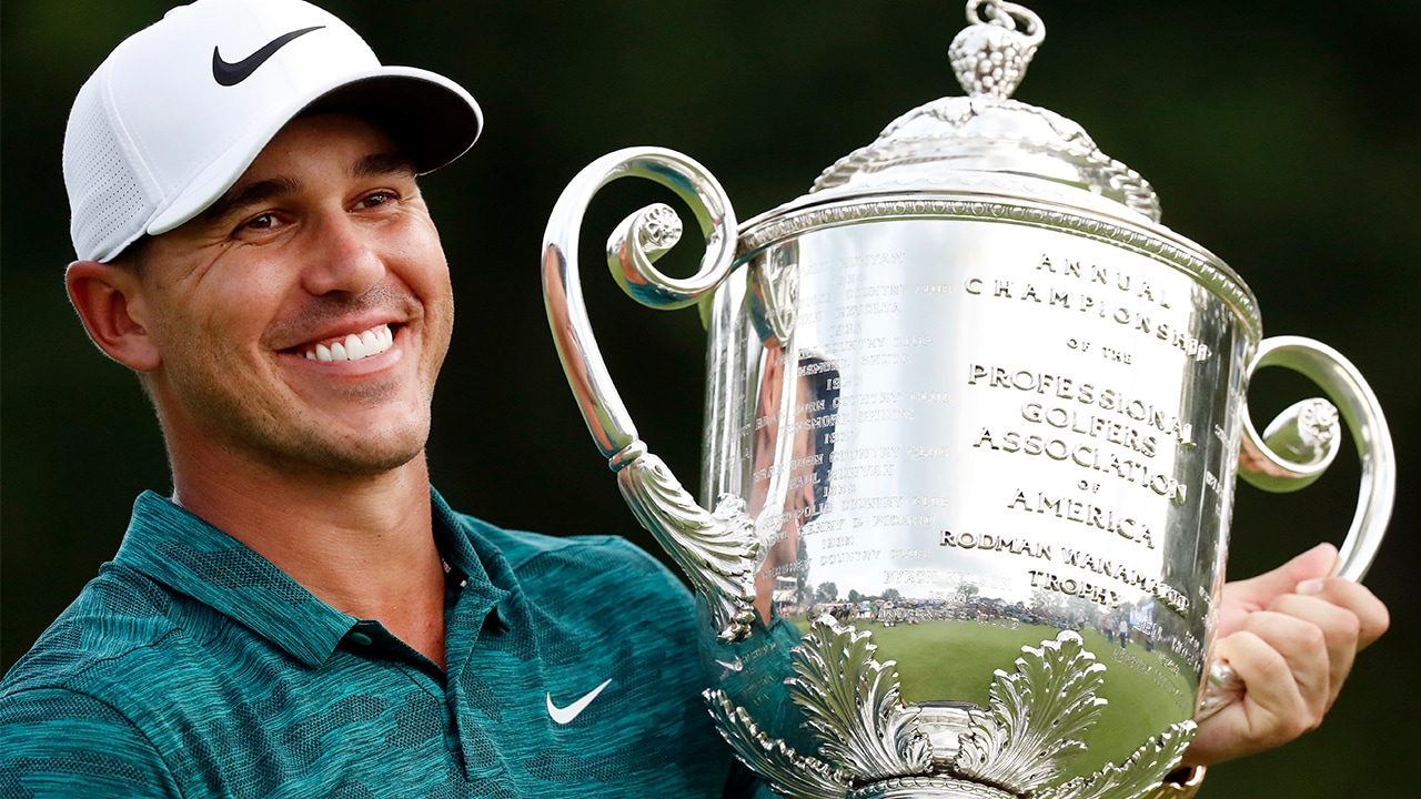 Photo of Brooks Koepka holding the Wanamaker Trophy