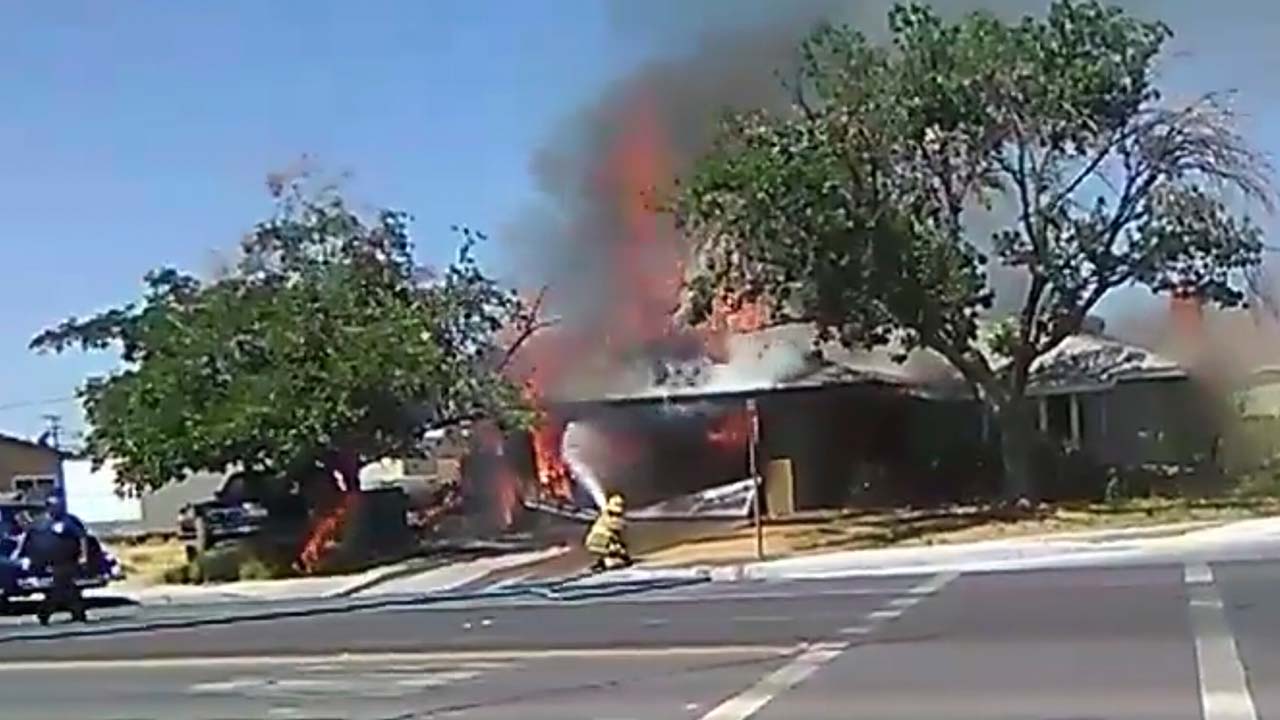 Photo of firefighter spraying a fire after California's Fourth of July earthquake