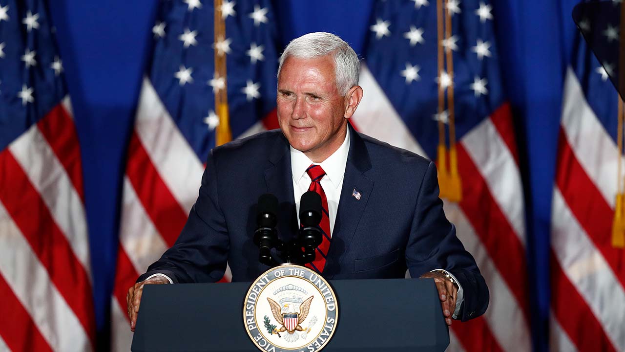 Photo of VP Mike Pence in front of American flags