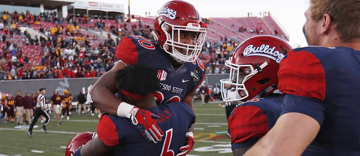 Photo of Fresno State defensive back Anthoula Kelly holding up game MVP running back Ronnie Rivers
