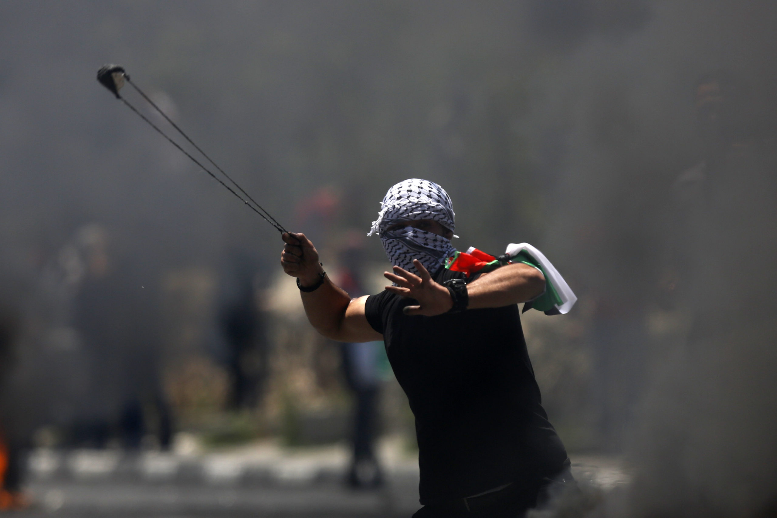 A Palestinian protester hurls a stone during clashes with Israeli forces