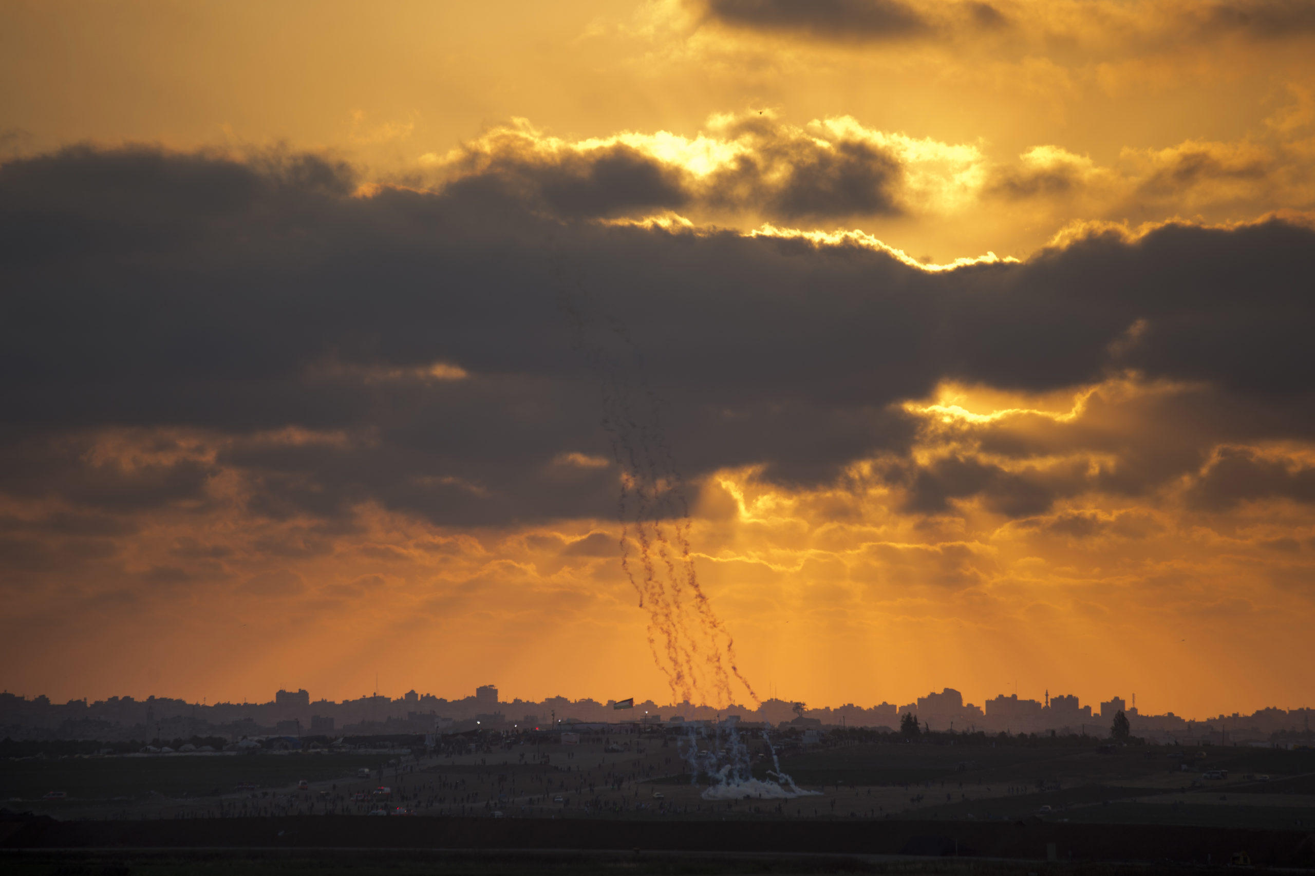 Palestinian protesters run from gas fired by Israeli troops in the Gaza Strip Border.