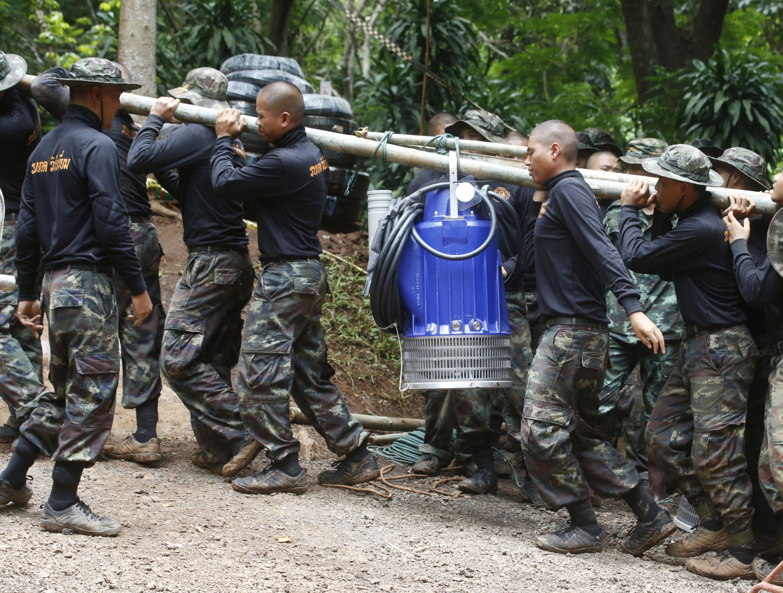Photo of soldiers carrying a pump to drain Thai cave