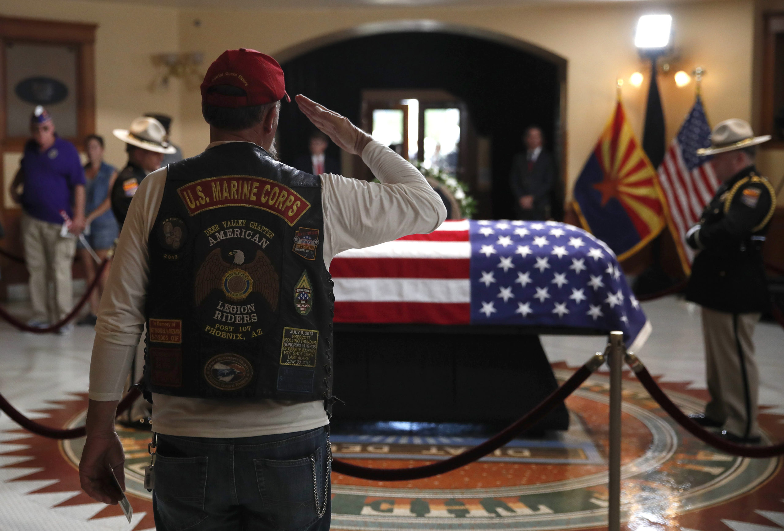 Photo of retired Marine saluting the casket of John McCain