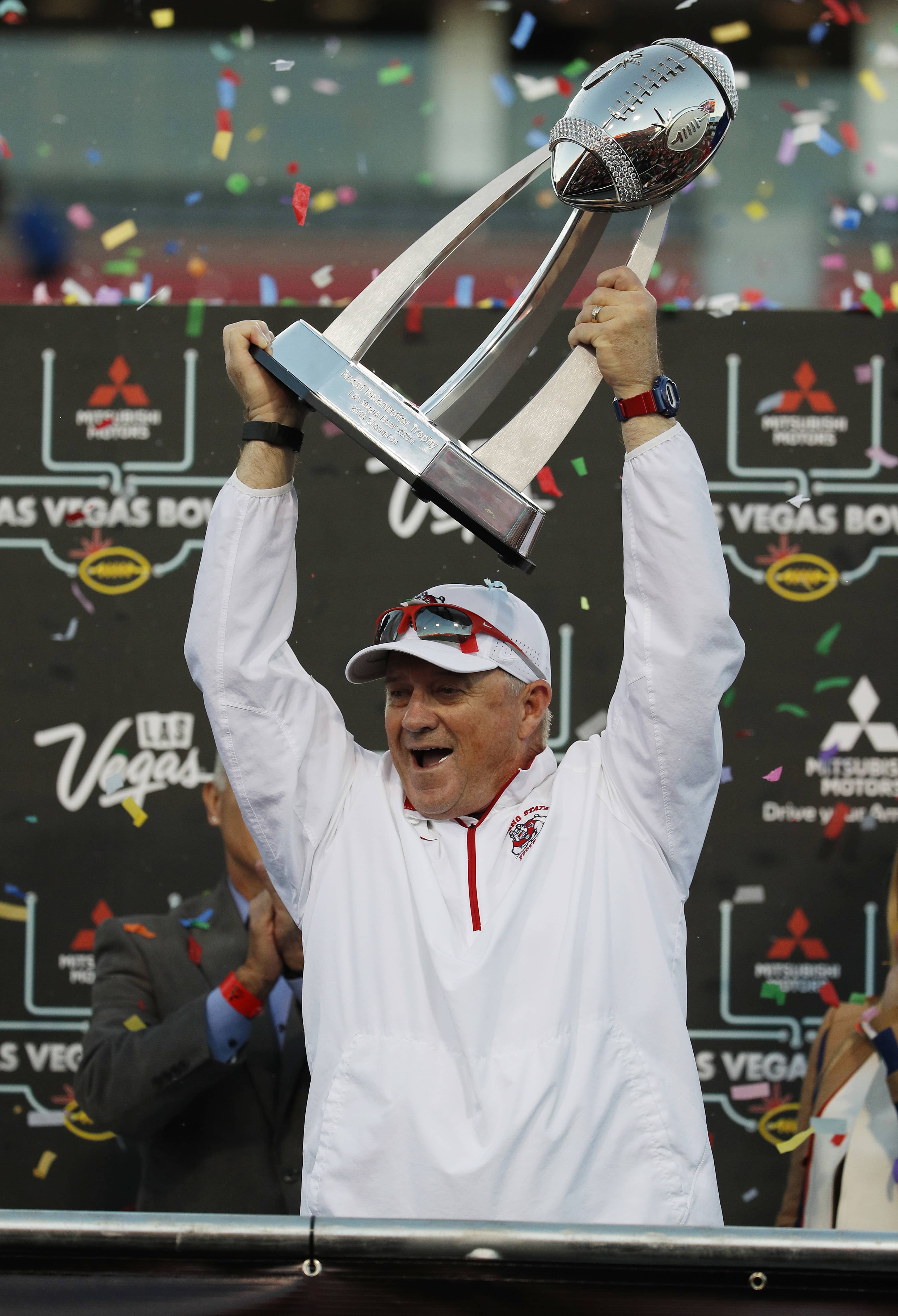 Photo of Fresno State football coach Jeff Tedford holding the trophy
