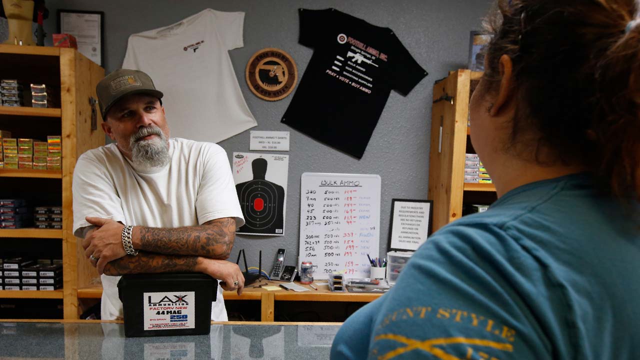 Photo of gun shop owner and customer