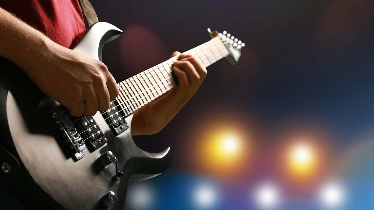 Photo of a man playing a guitar