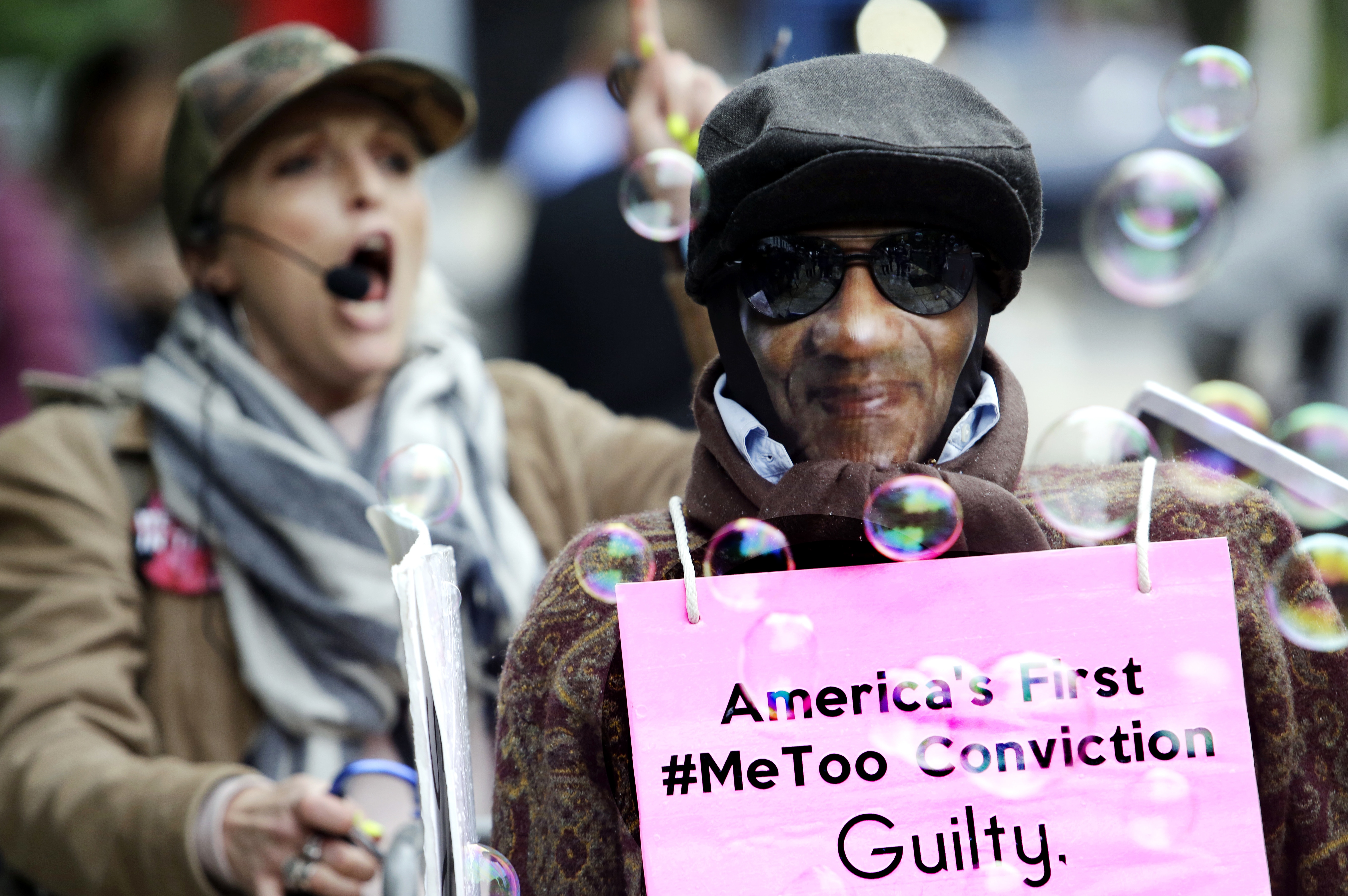 Photo of activist pushing a shopping cart with a likeness of Bill Cosby before he arrived for his sentencing hearing