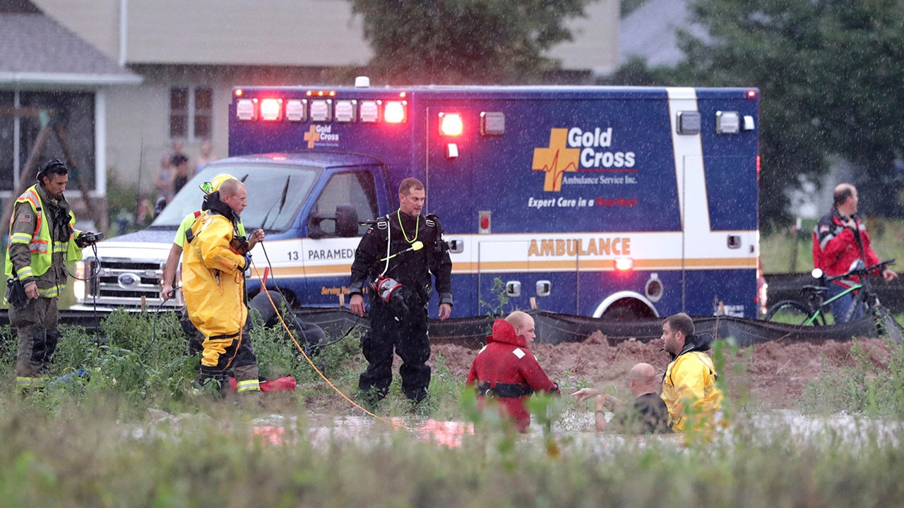 Photo of emergency responders rescuing boy that got sucked into a storm sewer