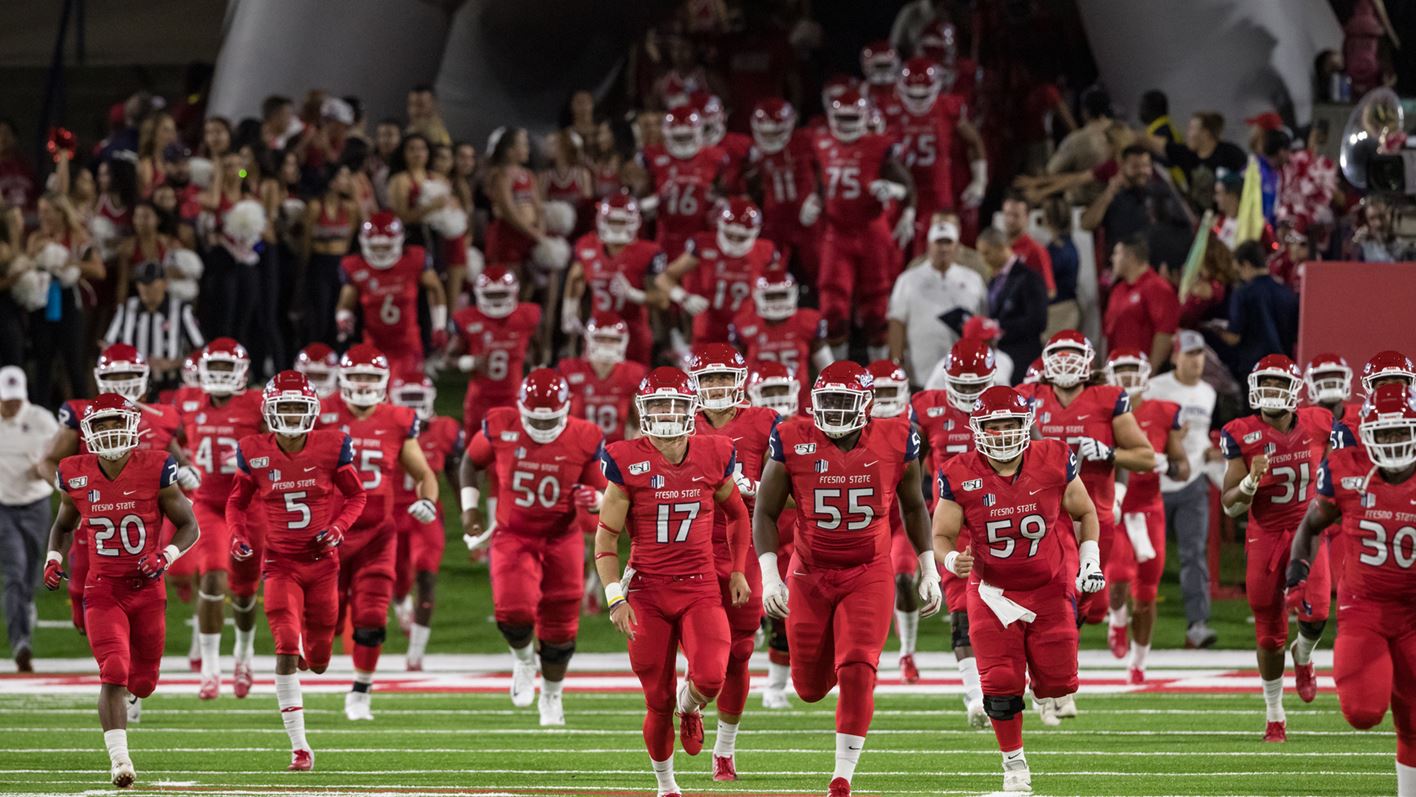 Photo of Fresno State football players running onto the field at Bulldog Stadium