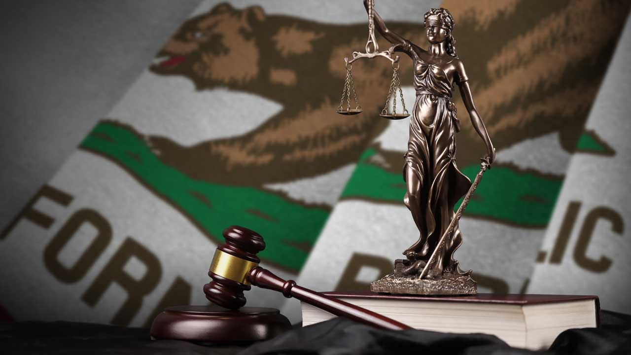 Composite image of California flag and a bronze of Lady Justice