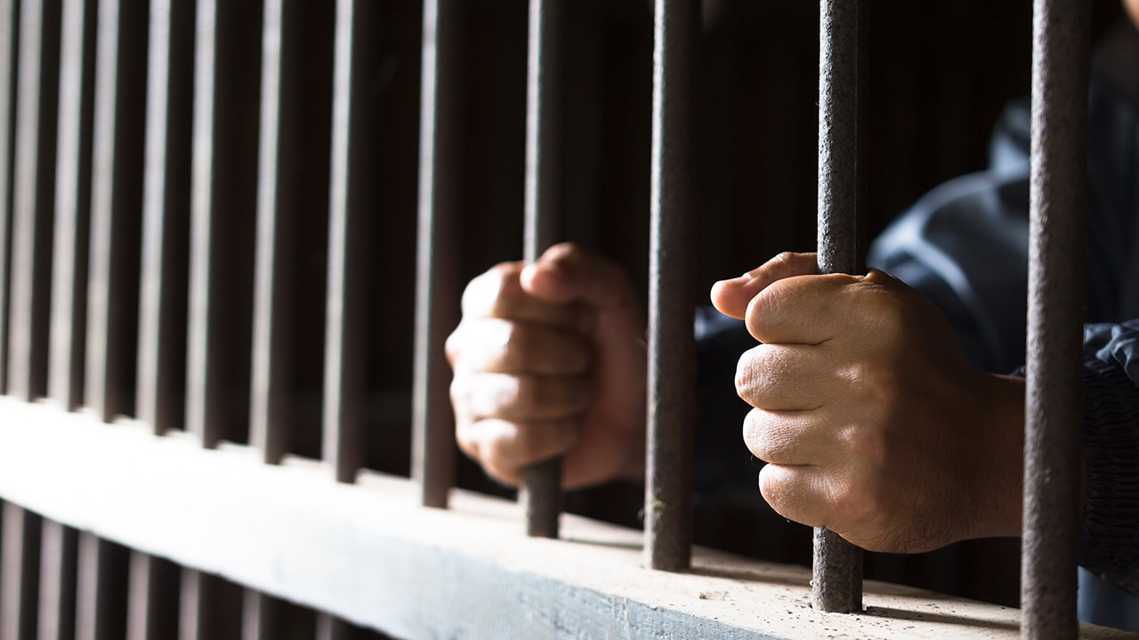 Closeup photo of man's hands isolated in jail