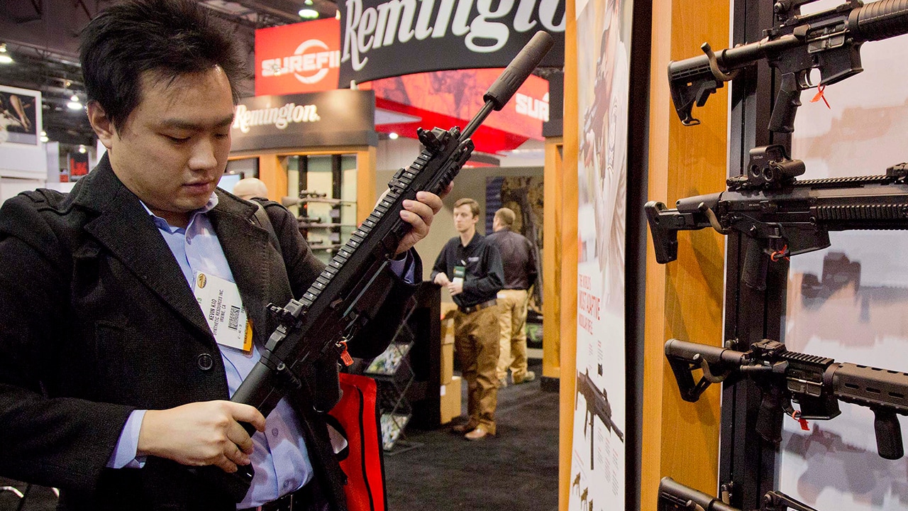 Photo of accessories manufacturer Kevin Kao examining a military grade Remington Adaptive Combat Rifle