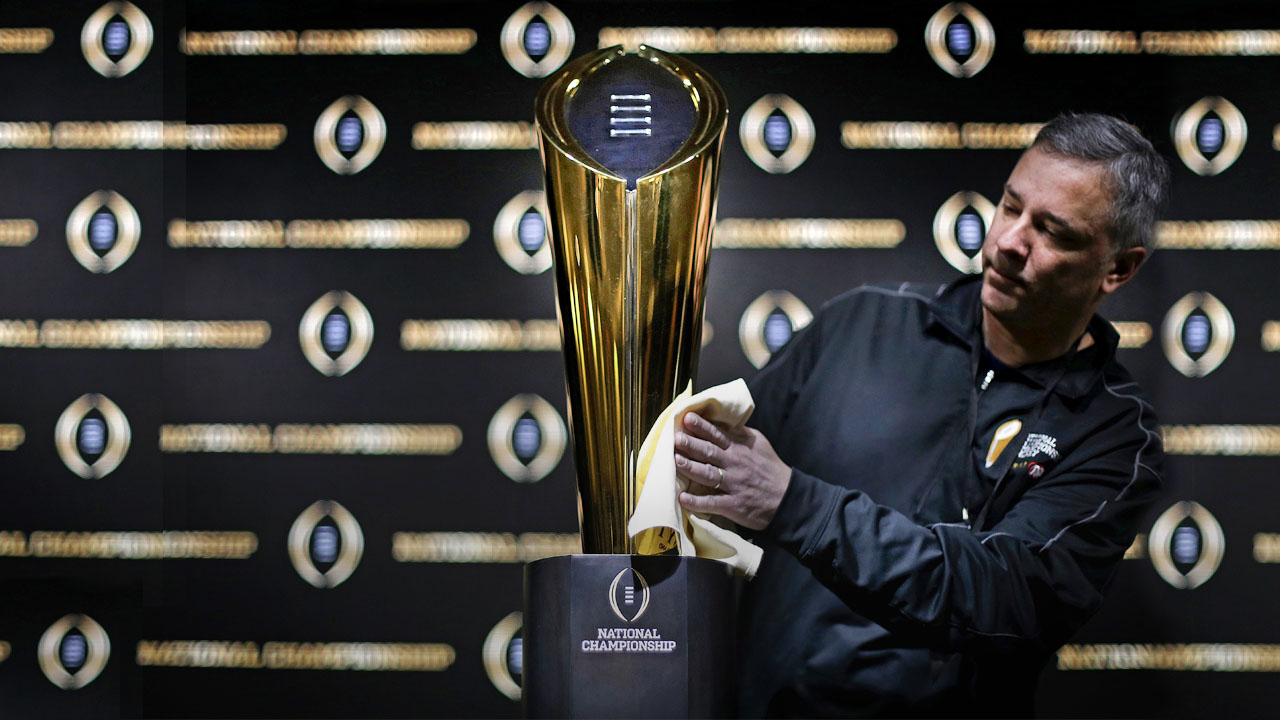 Photo of Charley Green buffing the NCAA college football championship trophy