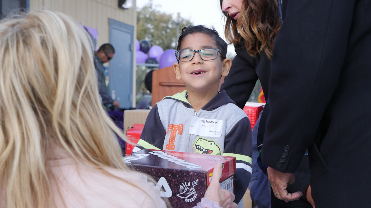 Photo of Tilley Elementary School student getting a new pair of tennis shoes from the nonprofit Shoes That Fit