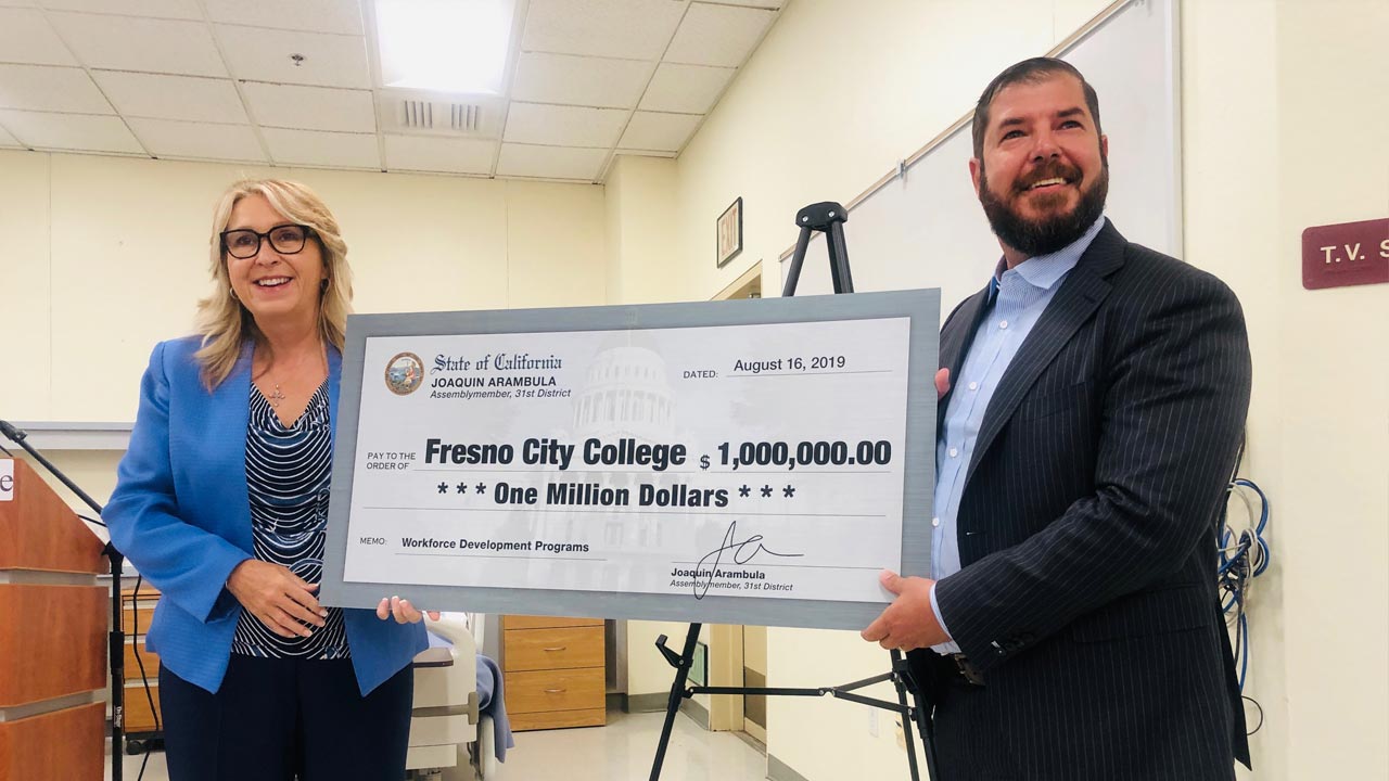 Photo of Carole Goldsmith and Assemblyman Joaquin Arambula holding a check