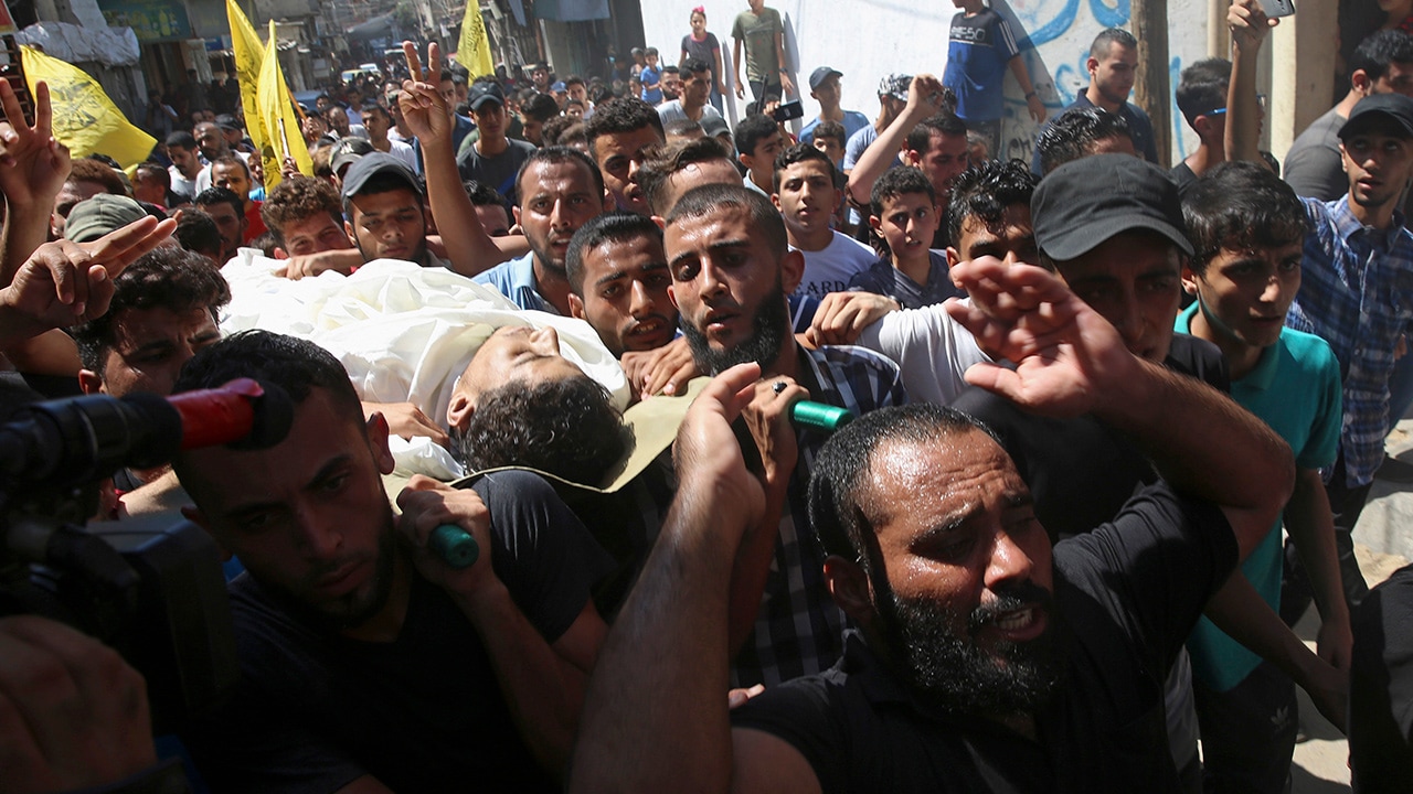 Photo of mourners chanting while carrying the body of Ahamd Omar