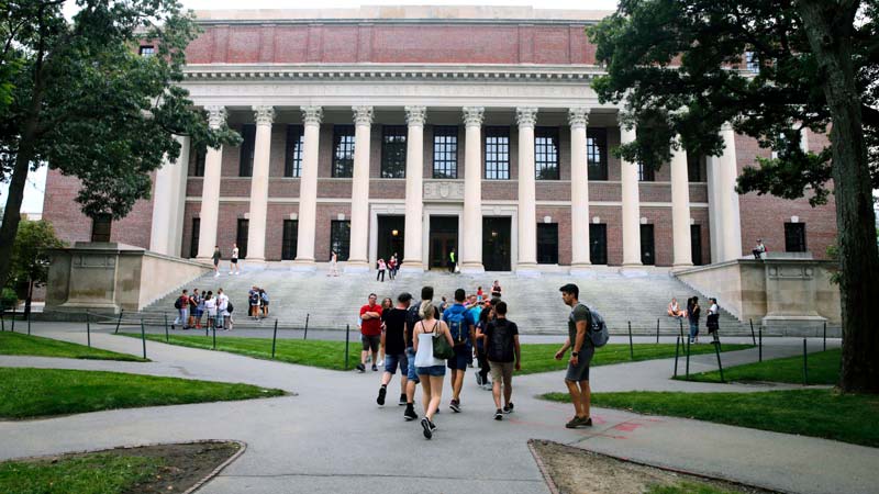 In this Aug. 13, 2019 file photo, students walk near the Widener Library in Harvard Yard at Harvard University in Cambridge, Mass. University and federal officials confirmed that incoming Harvard University student Ismail Ajjawi, 17, of Lebanon, was refused entry into the U.S. after landing at Logan International Airport in Boston on Friday, Aug. 23. (AP Photo/Charles Krupa, File)