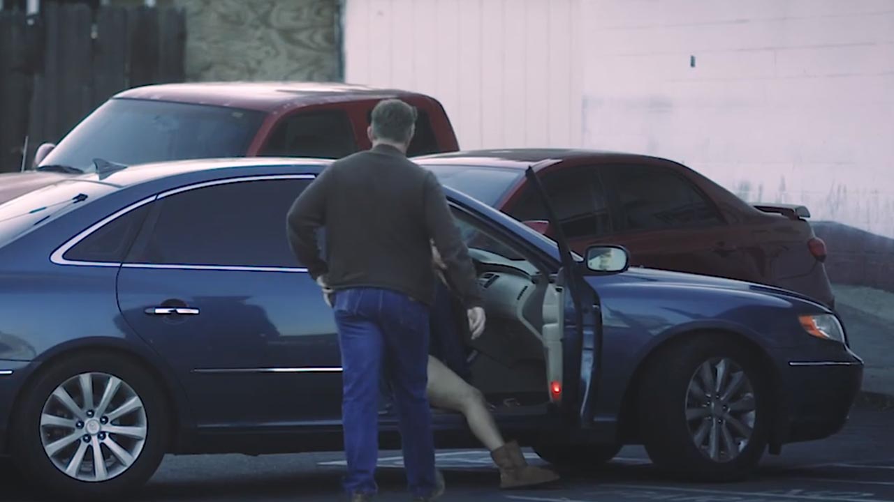 Photo of an undercover cop approaching a suspected prostitute in a car