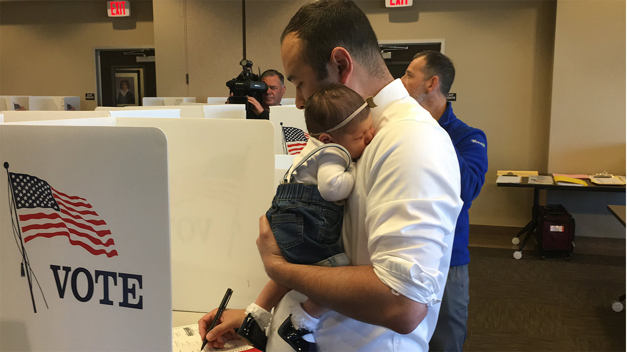 Photo of Andrew Janz voting with his daughter