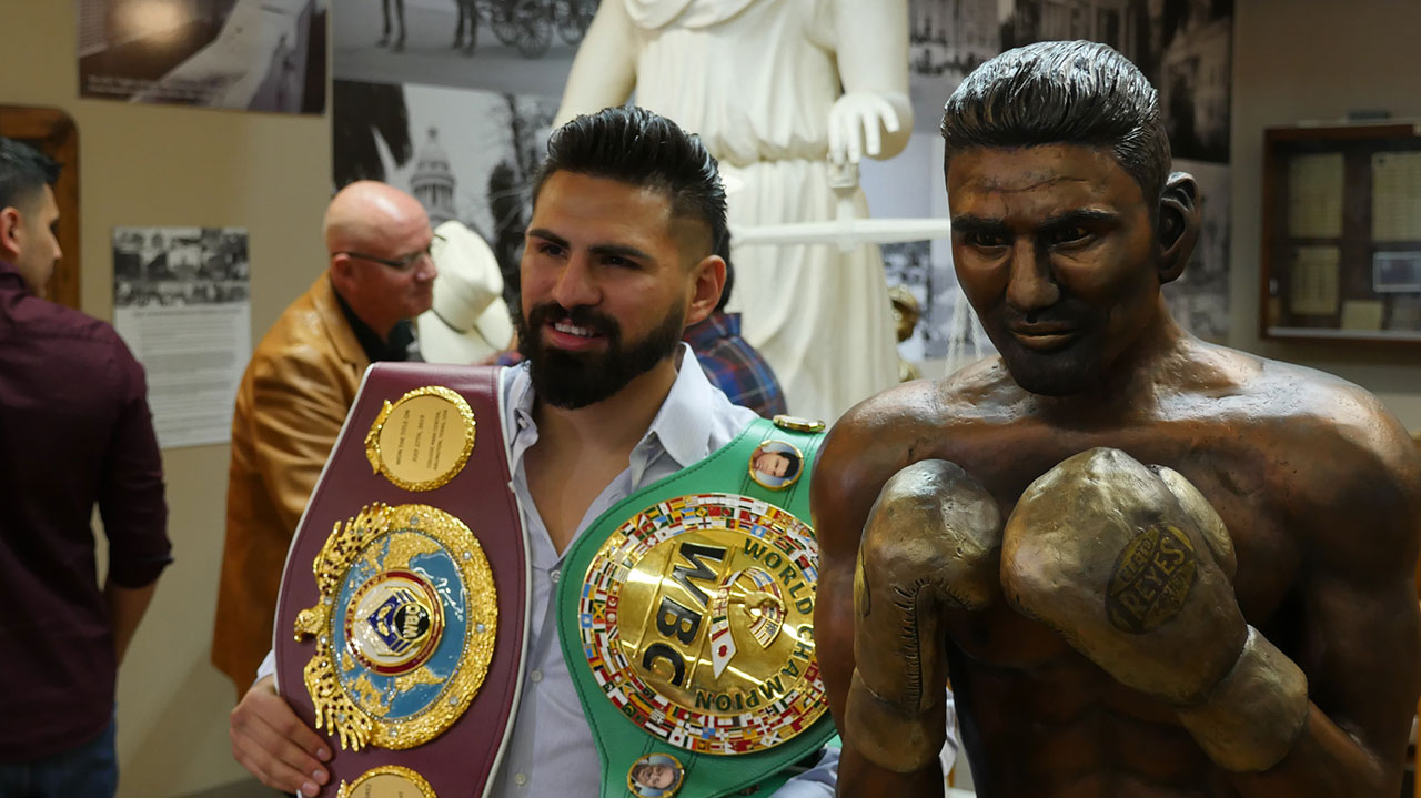 Photo of world boxing champion Jose Ramirez posing beside his statue in Fresno, California