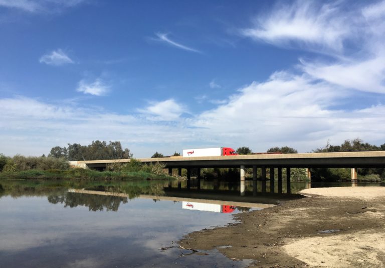 Photo of a big rig crossing a bridge on Highway 99 over the Kings River