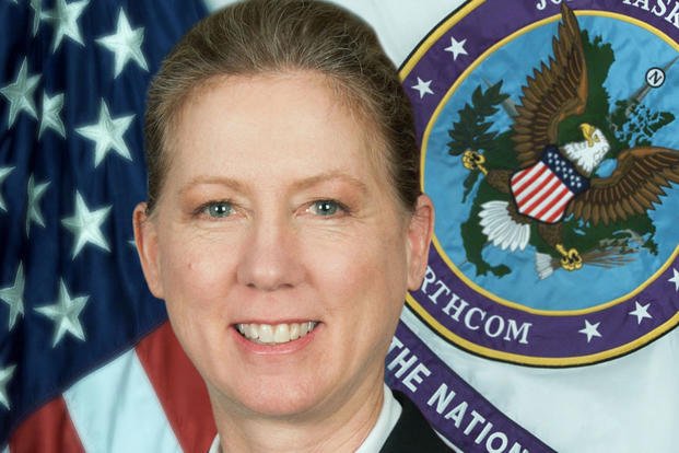 Photo of Brig. Gen. Laura Yeager in front of an American flag and military emblem