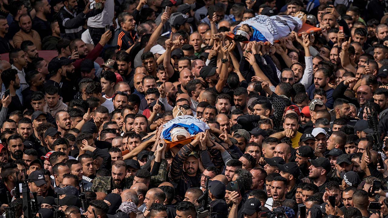 Mourners carry the bodies of Palestinians who were among five killed in an overnight Israeli raid