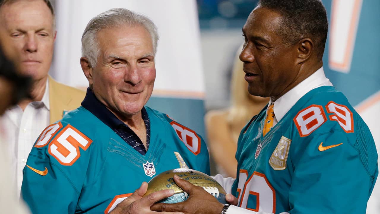 Miami Dolphins player Nick Buoniconti (85) is presented a football by former player and current Dolphins senior vice president of special projects and alumni relations, Nat Moore