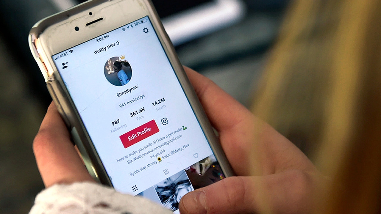 Photo of Matty Nev Luby holding her smartphone