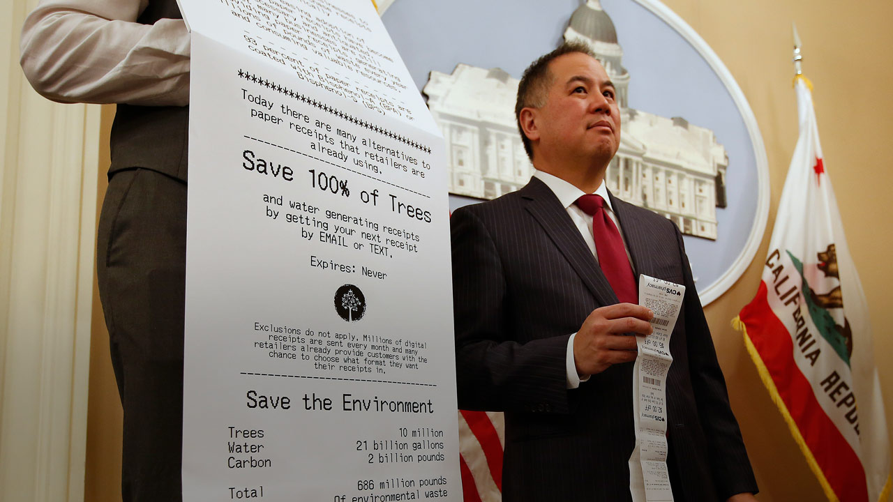 Photo of Assemblyman Phil Ting of San Francisco with a long paper receipt