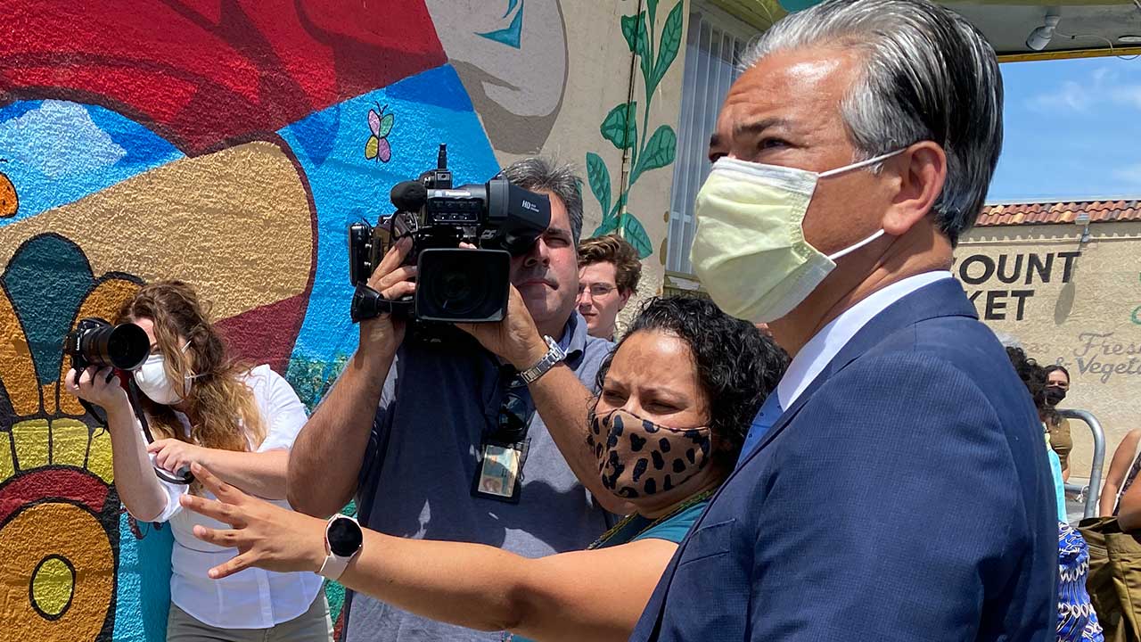 Building Healthy Communities CEO Sandra Celedon (center and pointing) shows state Attorney General Rob Bonta a mural at the Friends of Calwa building during the COVID-19 pandemic. (GV Wire/David Taub)