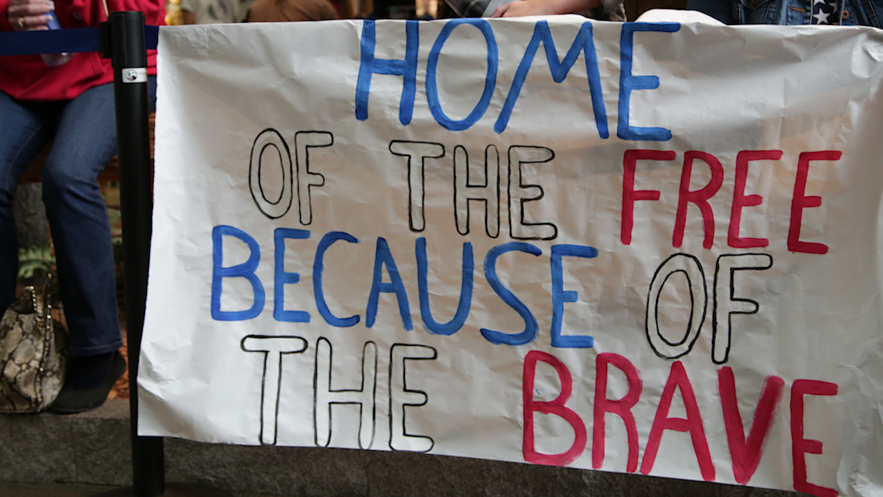 Supporters hold signs welcoming veterans home from the 17th Central California Honor Flight.