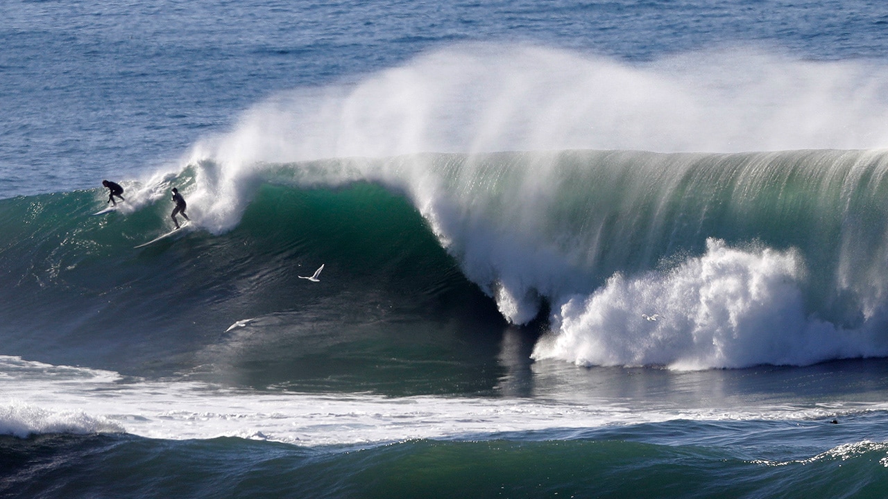 Photo of two surfers sharing a wave in Half Moon Bay, California