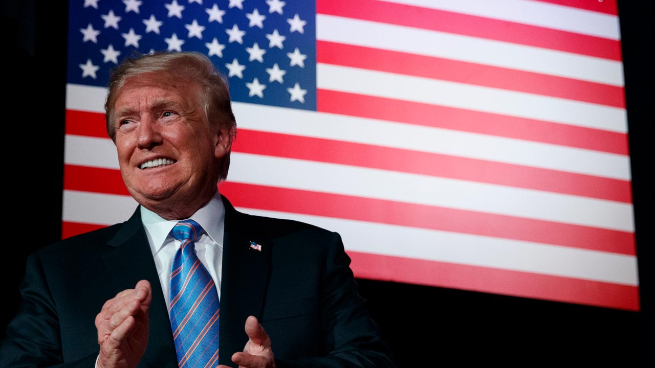 President Trump standing in front of the American flag