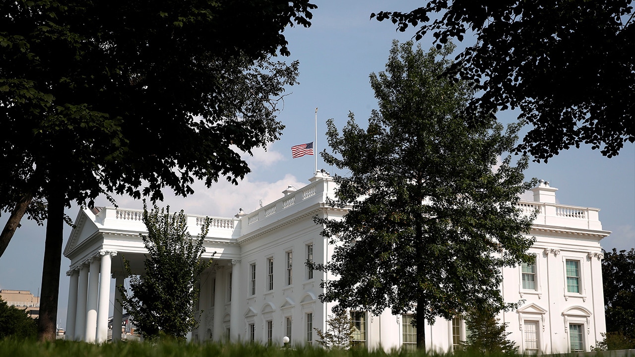 Photo of the American flag flying half-staff at the White House in Washington