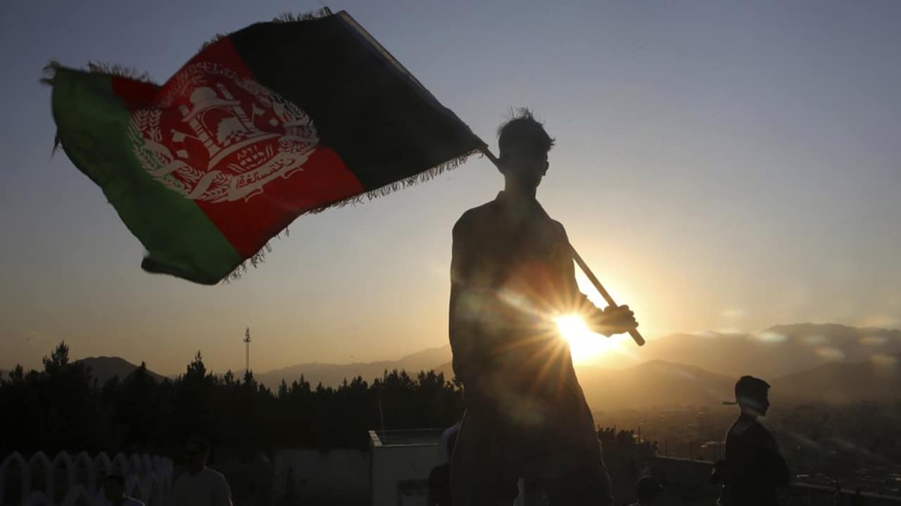 Photo of a man waving an Afghan flag in Kabul 
