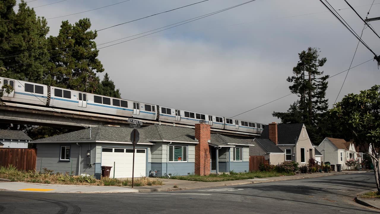 Photo of a BART train running about housing in Albany
