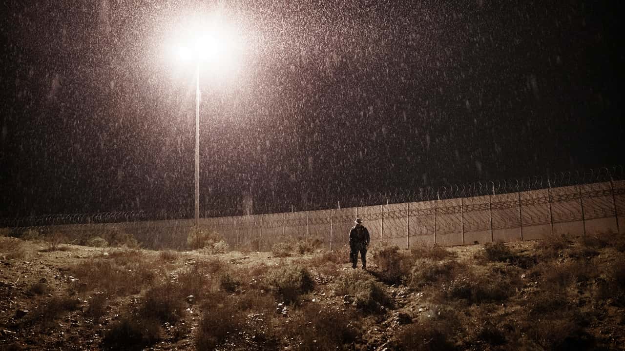 Photo of a U.S. Border Protection officer standing in the rain