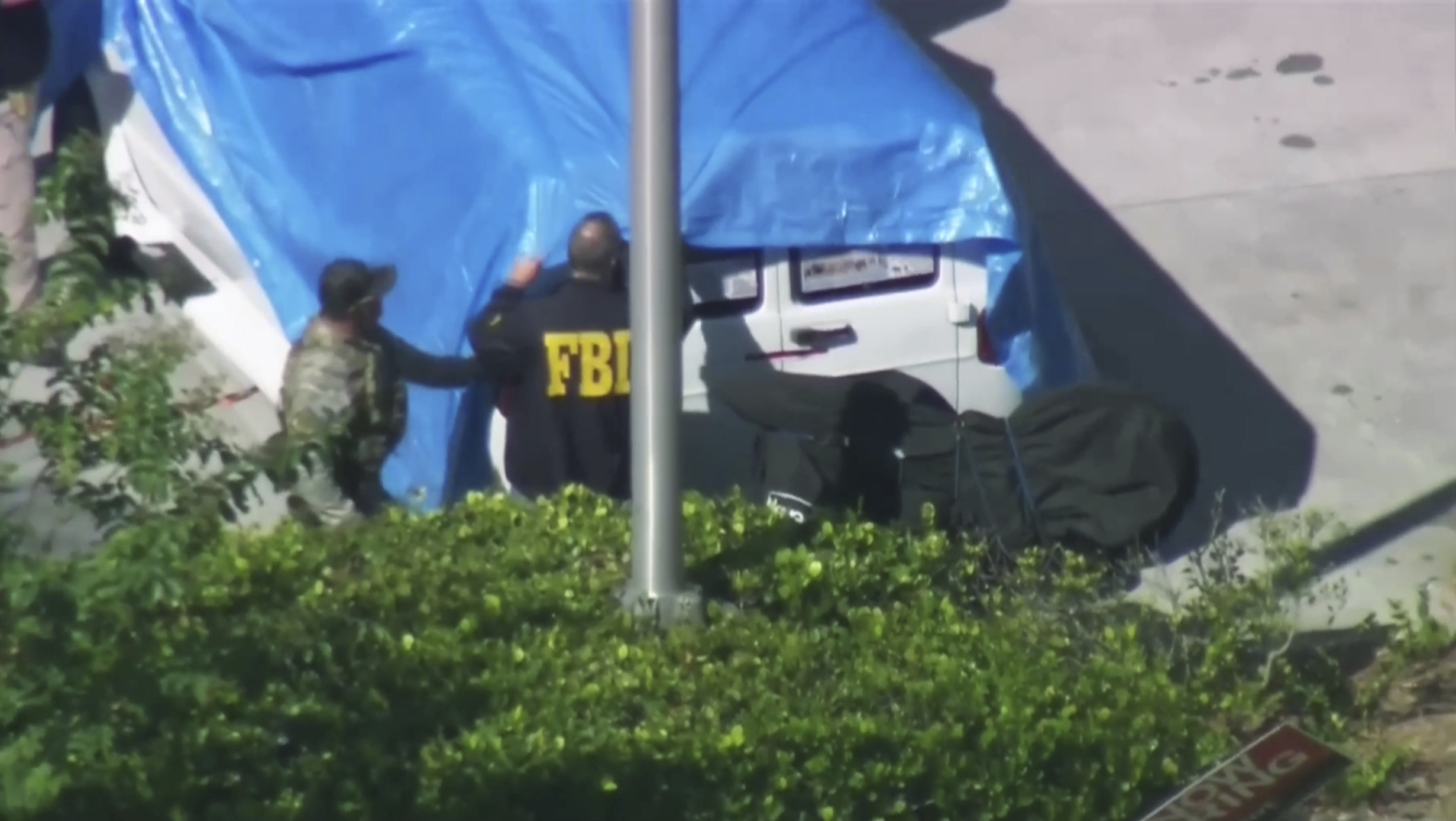 Photo of agents covering a van