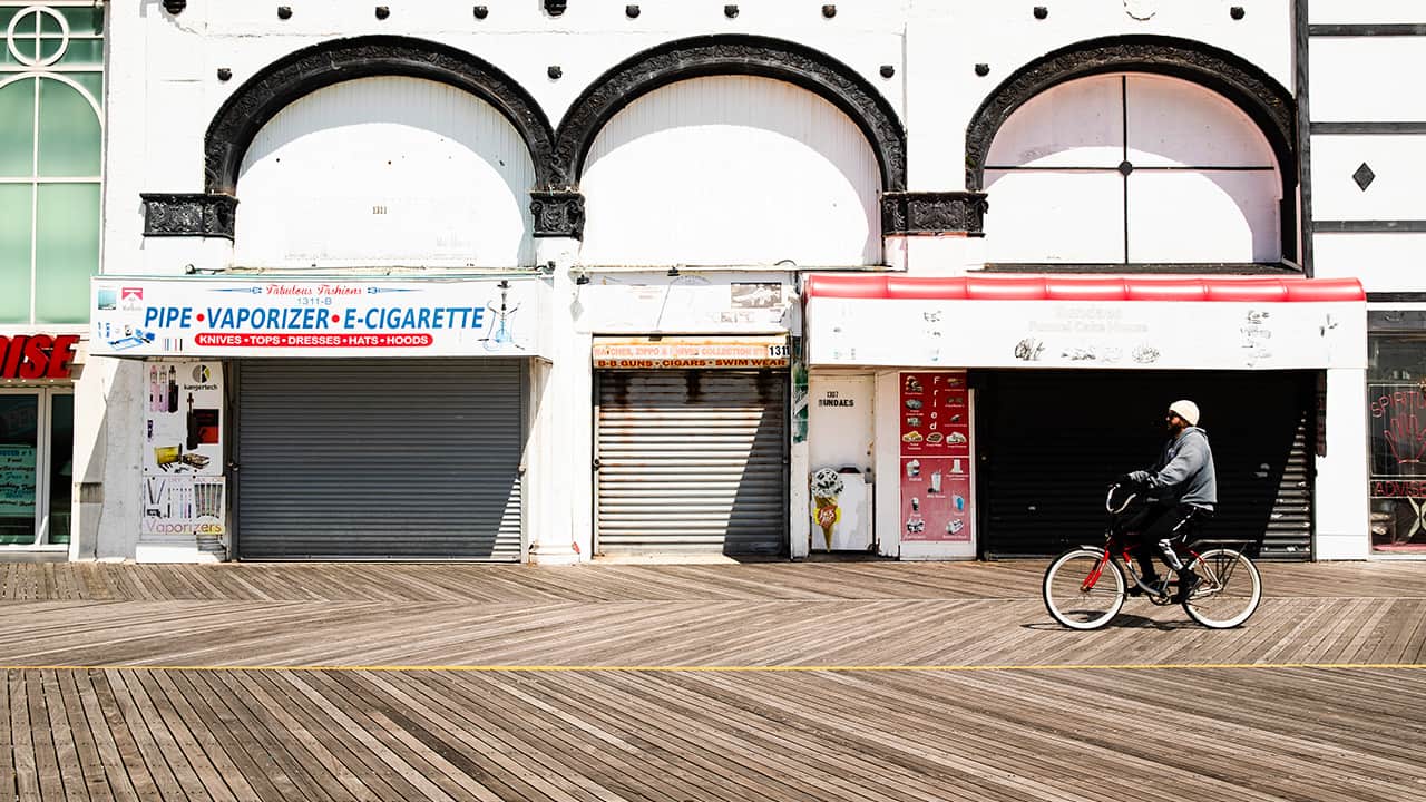Photo of a cyclist riding past shuttered businesses in Atlantic City 