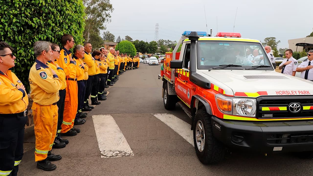 Photo of New South Wales Rural Fire Service crew watch as the casket of NSW RFS volunteer Andrew O'Dwyer arrives for his funeral