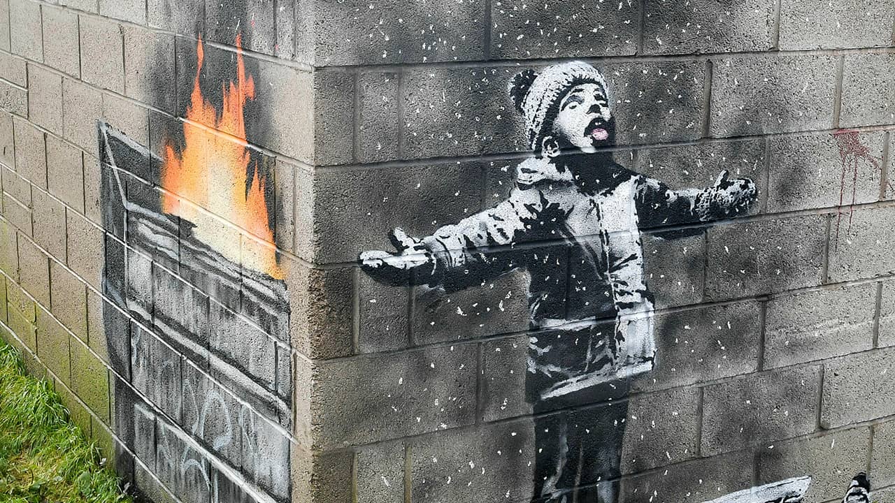 Photo of mural by Banksy on the side of a garage