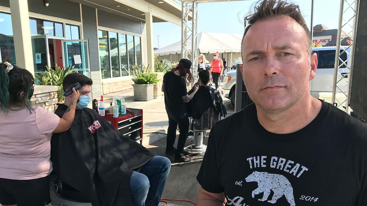 The Great American Barbershop founder Tye Featherstone stands by his makeshift parking lot setup Thursday morning. (GV Wire/Jim Jakobs)