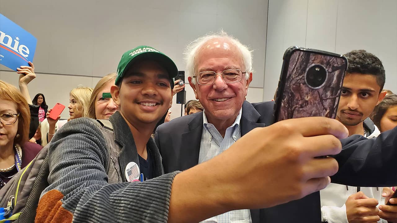 Photo of man snapping a photo with Sen. Bernie Sanders