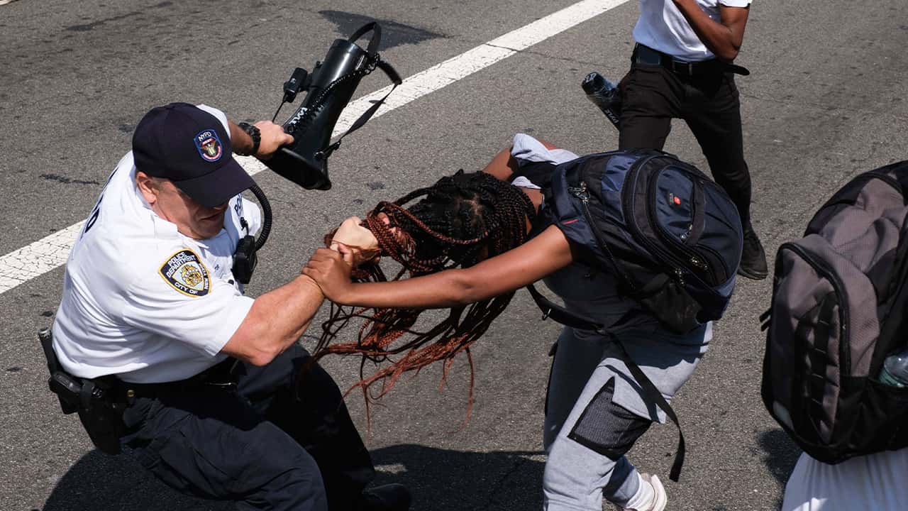 Photo of protesters struggling with an officer